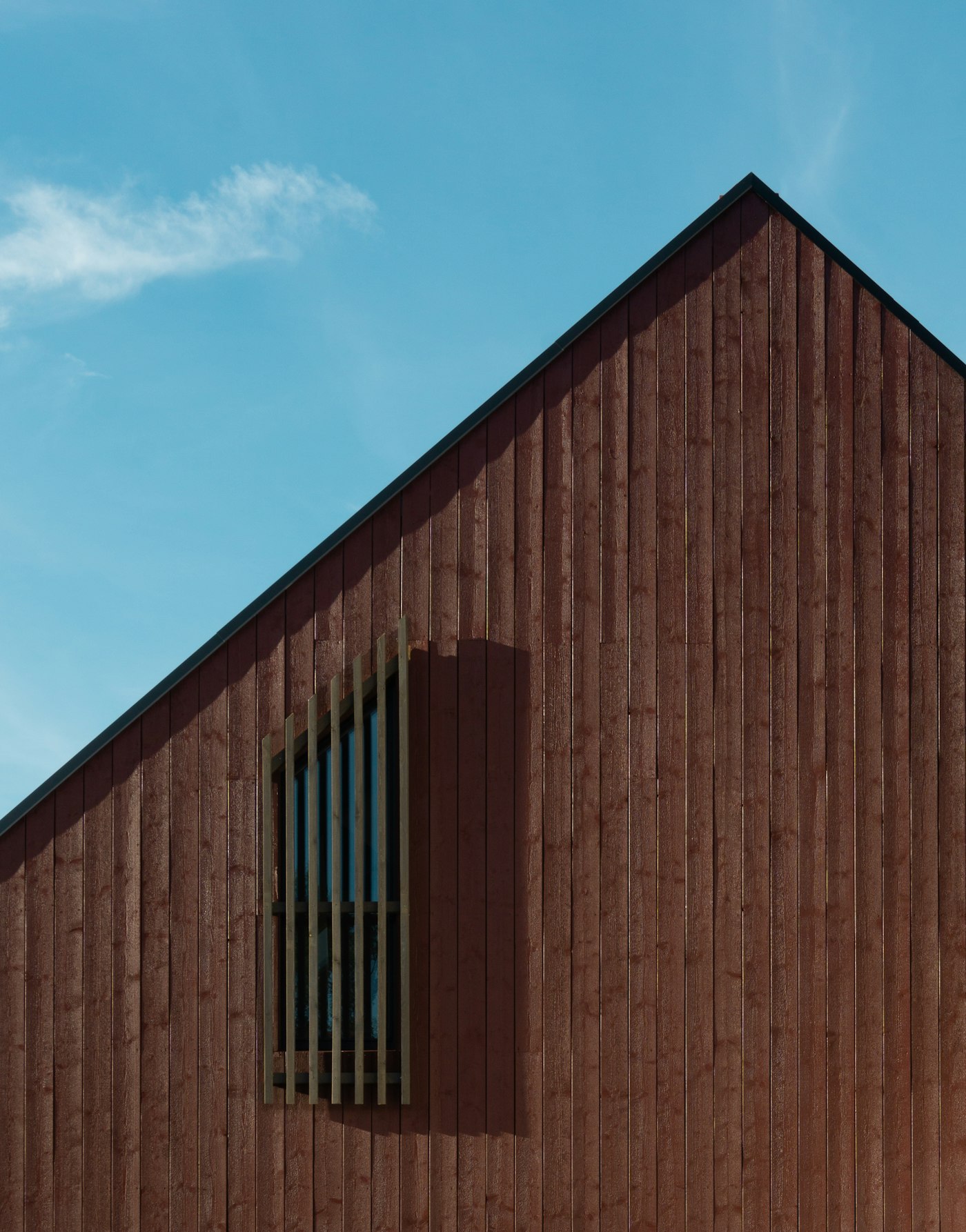 A minimal timber-clad building with a single window — sustainable architecture